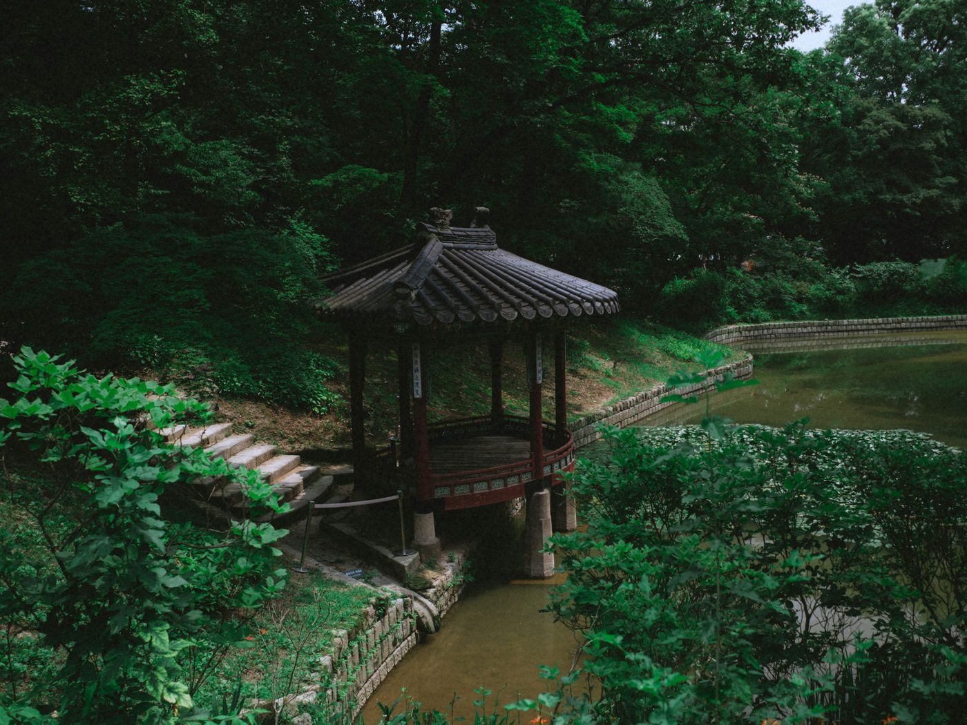 숲 속 연못가에 선 목조 정자